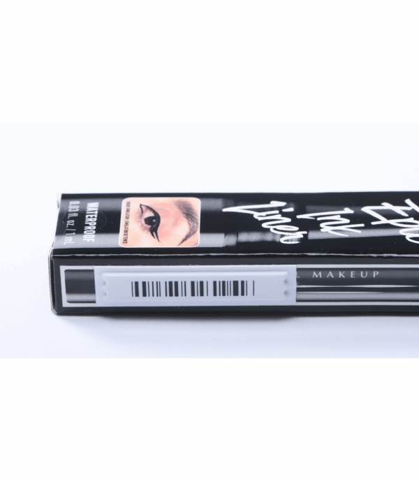 photographie d'une étiquette antivol adhésive AM posée sur la tranche d'une boîte d'eye liner