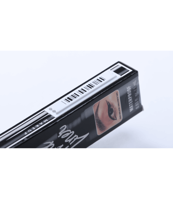 photographie d'une étiquette antivol adhésive AM posée sur la tranche d'une boîte d'eye liner de travers