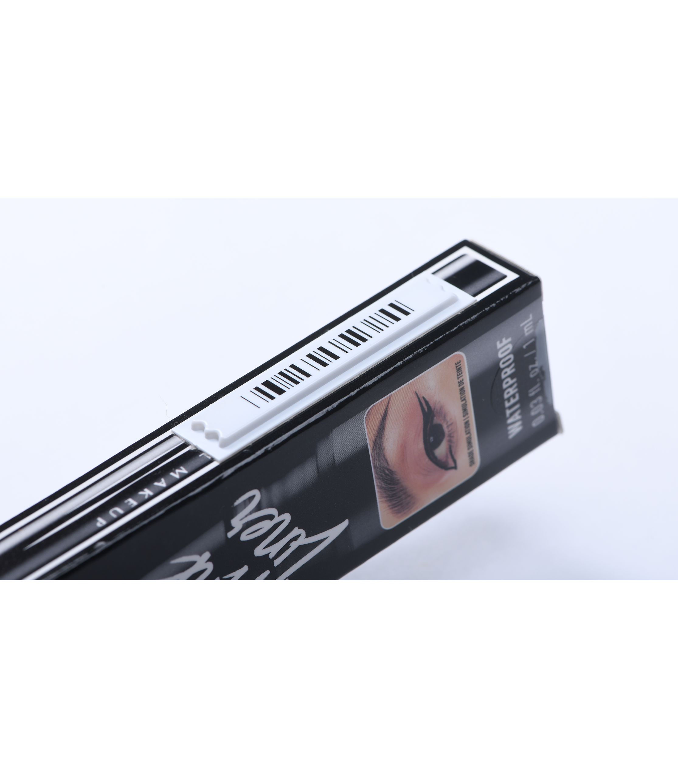 photographie d'une étiquette antivol adhésive AM posée sur la tranche d'une boîte d'eye liner de travers