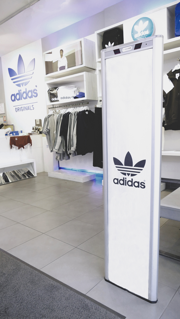 Photographie d'un portique Alupub en situation dans un magasin Adidas avec une gaine publicitaire de la même marque.